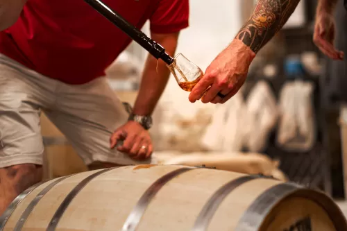 Selecting a sample of whisky from the barrel